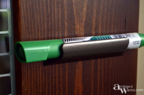 Old drawer pull used to hold the dry erase markers