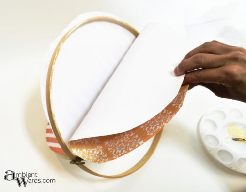 Putting on the 2nd piece of scrapbook paper onto the embroidery hoop mobile
