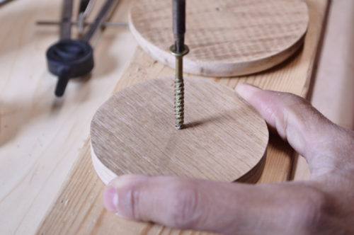 Drilling the screw into the center of the lid