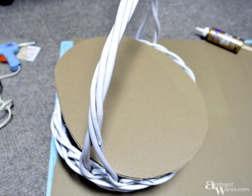 Woven basket painted white and trimming a piece of cardboard for the floor