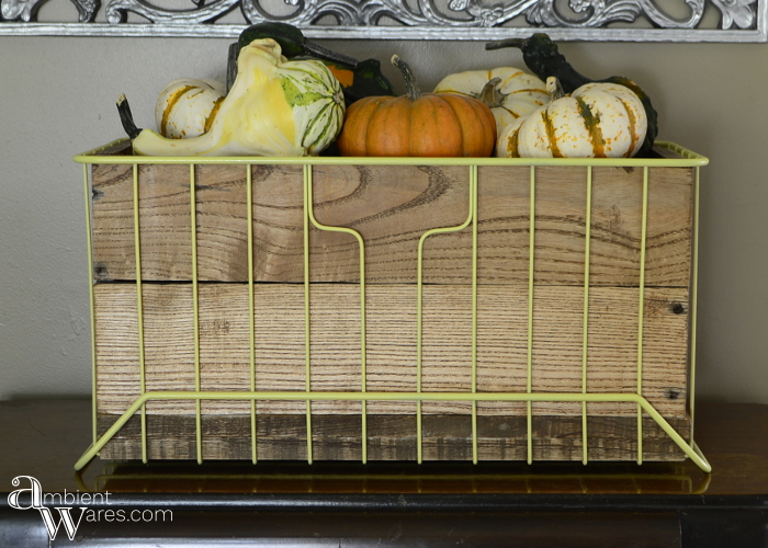 A metal basket gets a DIY pallet wood insert. Two baskets in one! For this and more unique project ideas, visit AmbientWares.com