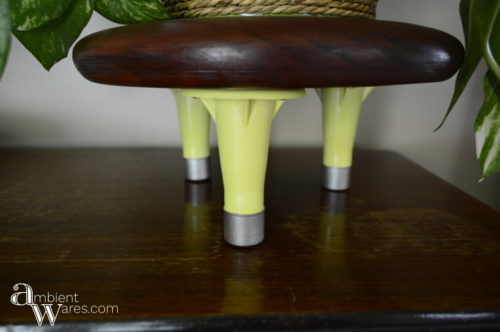Come see how a wooden seat and old bed frame feet were combined to make a cute mid-century vibed plant stand! For this and more unique project ideas, visit AmbientWares.com!