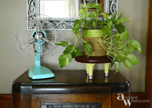 Come see how a wooden seat and old bed frame feet were combined to make a cute mid-century vibed plant stand! For this and more unique project ideas, visit AmbientWares.com!